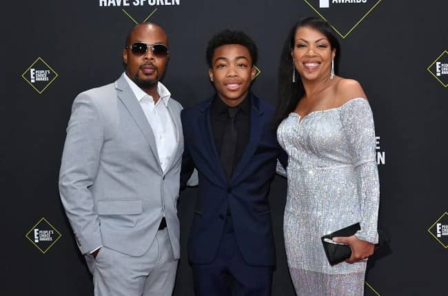 Blacck's wearing navy blue suit with black shirt and his father is wearing grey suit with white shirt and his mother is wearing sliver one piece.